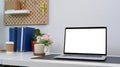 Mock up computer laptop with blank screen and office supplies on white desk in home office. Royalty Free Stock Photo