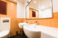 close up view of modern bathroom in orange and white colors Royalty Free Stock Photo