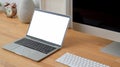 Close up view of modern workspace with blank screen laptop, computer and decoration on wooden desk Royalty Free Stock Photo