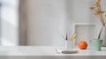 Close up view of workspace with copy space, stationery, coffee cup, and decorations on white table with blurred background