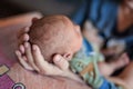 Close-up view of mother holding little head of her cute peaceful newborn baby in her hands Royalty Free Stock Photo