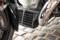 Close-up view of motorcycle engine detailing showcasing unique design elements and textures during bright daylight in an urban Royalty Free Stock Photo