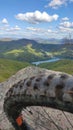Close-up view of MTB mountain bike wheel with cleats the top of a mountain lookout overlooking a lake Royalty Free Stock Photo