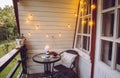 Close up view of nautical theme home balcony at night with string light bulbs.