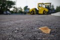 Close up view on the new asphalt road on which steamroller is working. Highway construction site