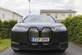 Close up view of new BMW IX40 electric car in villa`s private parking lot on cloudy summer day.