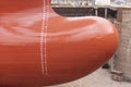 Close up view on the newly red painted bulbous bow of the big container ship.