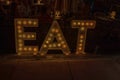 Close-up view of night bar with LED lights and sign EAT welcoming people into bar. Miami Beach.