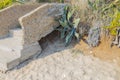 Close up view of okd broken abandoned stone stair part on sandy landscape.