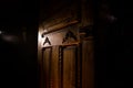 Close up view of old antique wooden door inside dark room. Selective focus Royalty Free Stock Photo