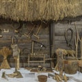 Close-up view with old attributes of rural life. Yarn, sickle, seive, clamp, log, saw, spinning wheel and other things Royalty Free Stock Photo