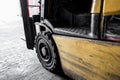 Close-up view of an old forklift truck showing the small tyre and tread.