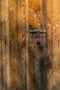 Close up view of the old rusty padlock on a aged gray wooden door Royalty Free Stock Photo