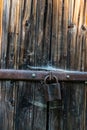 Close up view of the old rusty padlock on a aged gray wooden door Royalty Free Stock Photo