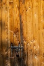 Close up view of the old rusty padlock on a aged gray wooden door Royalty Free Stock Photo