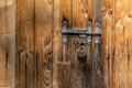 Close up view of the old rusty padlock on a aged gray wooden door Royalty Free Stock Photo