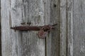 Close up view of the old rusty padlock on a aged gray wooden door Royalty Free Stock Photo