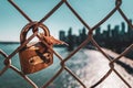 Close up view of the old rusty padlock on the bridge with the blurry Manhattan skyline in the background. Royalty Free Stock Photo