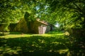 Close-up view of an old stone barn in the shade of trees. Royalty Free Stock Photo