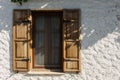 Close up view of old, traditional house window with wooden shutters white plaster wall captured in famous, touristic Aegean town c Royalty Free Stock Photo