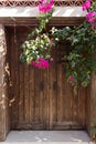 Close up view of old, wooden door and bougainvillea flowers in famous, touristic Aegean town Royalty Free Stock Photo