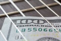 Close up view on a hundred dollars between the strings of guitar Royalty Free Stock Photo