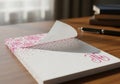 Elegant pink floral patterned notepad with a pen on a wooden desk isolated on white background Royalty Free Stock Photo