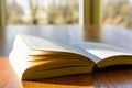 Open book on a wooden table with sunlight Royalty Free Stock Photo