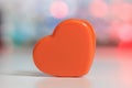 Close up view of Orange plastic heart against illuminated background