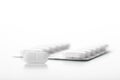 Close-up view of an oval tablet or pain pill and out of focus blister. Isolated on white background - with space for text