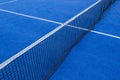 Net an lines on a blue paddle tennis court, synthetic grass