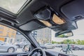 Close-up view of panoramic sunroof control panel in car with interior lights on.