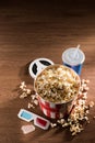 close up view of paper bucket with popcorn, soda drink, 3d glasses and retor cinema tickets on wooden tabletop Royalty Free Stock Photo