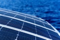 Close up view part of solar panel on dock of sailboat and blue sea waters Royalty Free Stock Photo