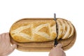 Close up view of partially sliced loaf of bread on wooden cutting board with bread knife. Royalty Free Stock Photo