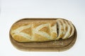 Close up view of partially sliced loaf of bread on wooden cutting board with bread knife. Royalty Free Stock Photo