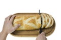 Close up view of partially sliced loaf of white bread on wooden cutting board with bread knife.