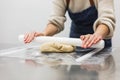 Close up view of a pastry chef kneading dough with a rolling pin at the kitchen table. Royalty Free Stock Photo