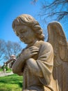 Close up view of praying angel statue on a spring garden background. Royalty Free Stock Photo