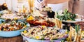 Close up view of people firends hands taking food from catering table during party celebration - food on a table -coloured backgro