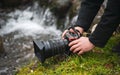 Close up view of a photo video mirrorless camera held in hand by a male photographer in nature landscape Royalty Free Stock Photo