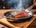 A close-up view of a piece of Wagyu steak cooking in a hot pan on a wooden table