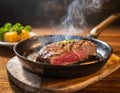 A close-up view of a piece of Wagyu steak cooking in a hot pan on a wooden table