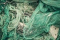 Close up view pile of green nylon multi colorful bright fish nets with pieces of white corals and old ropes in fishing Royalty Free Stock Photo