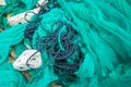 Close up view pile of green nylon multi colorful bright fish nets with pieces of white corals and old ropes in fishing Royalty Free Stock Photo