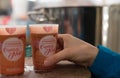 Close up view of plastic charity donation cups of mulled wine at the Christmas Market in Strasbourg with a female hand taking one