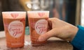 Close up view of plastic charity donation cups of mulled wine at the Christmas Market in Strasbourg with a female hand taking one