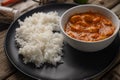 Close-up view of plate with delicious chicken tikka masala curry and rice on rustic wooden table with spices background. Royalty Free Stock Photo