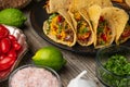 Close-up view of plate with hot mexican tacos on rustic wooden table with ingredients for cooking background. Concept of Royalty Free Stock Photo