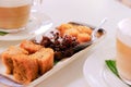 Close up view of plated cake snacks or kuihs, served with cappuccinos. This selection of delicious kuihs are typical Malay and Royalty Free Stock Photo